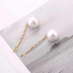 Set of two minimalist golden hair clips featuring elegant large white pearls on pins