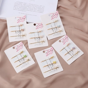 Détail d'un lot de barrettes papillon en émail coloré sur fond en tissu de soie élégant