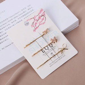 Lot de trois barrettes à cheveux avec nœuds roses sur carte de présentation