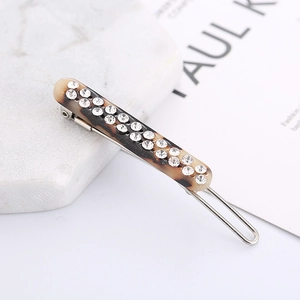 Detail of tortoise shell hair clip featuring double-row crystal rhinestones on metal base