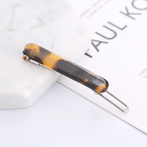 Chic leopard print acetate hair clip with silver metal frog buckle on marble surface