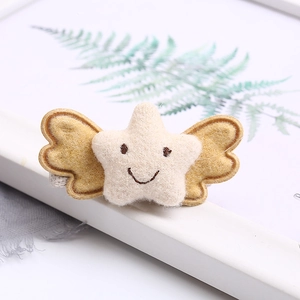Cute felt star hair clip with yellow wings and embroidered face on white tray