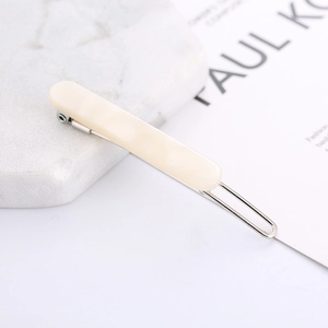 Detailed top view of a cream white marble acetate hair clip with silver metal base