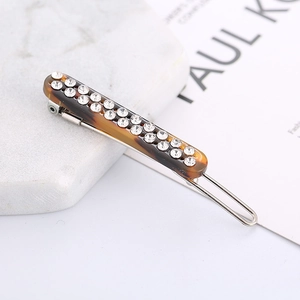 Close-up of leopard pattern hair clip with double-row rhinestones on marble