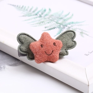 Detailed view of handmade felt star hair clip with smiley face and soft green wings