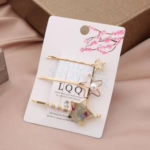 Three-piece gold star hair clip set with pearls and colorful marble texture detail
