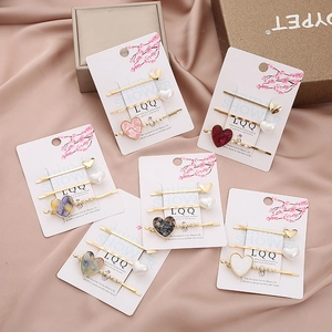Elegant 3-piece heart hair clip set with resin hearts and pearls on pink satin
