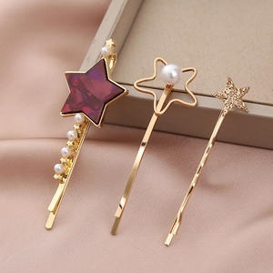 Detailed close-up of three-piece gold star hair clips with marble acrylic and pearls