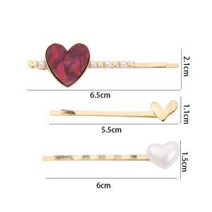 Three-piece set of heart-shaped hair clips with pearls and marble textures on a gold base