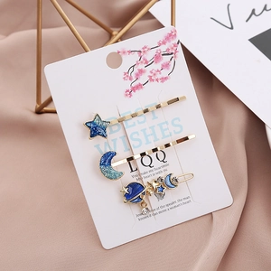 Three-piece celestial hair clip set with blue stars, moons and planets on gold metal