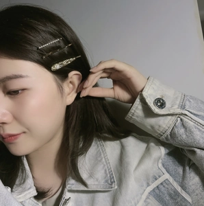 Close-up of gold hair clip set with pearls and rhinestones on a female model