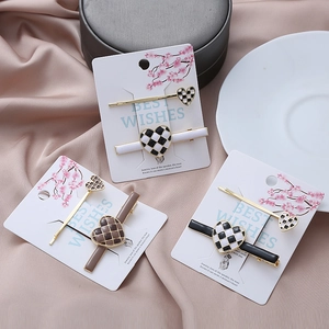 Checkerboard heart hair clip set with gold trim on pink satin background