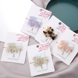Details von fünf bunten Haarklammern in Puzzleform auf elegantem lila Seidenstoff