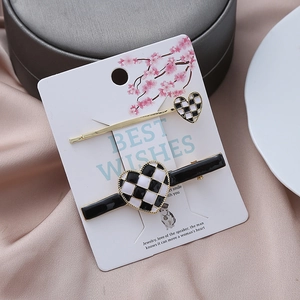 Checkerboard heart hair clip set with gold trim on decorative card display