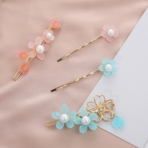 Dettaglio dei fermagli per capelli a ciliegio rosa con perle e base in lega dorata