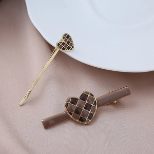 Detail of checkered heart hair clips with gold beading on elegant silk background
