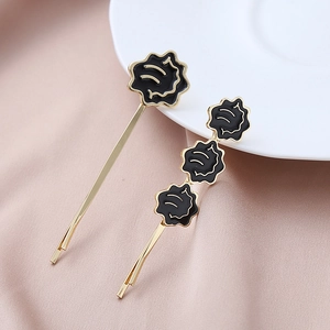 Détail de barrettes à fleurs en émail noir de style coréen sur socle en alliage doré