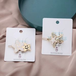 Détail de pinces à cheveux étoile de mer avec motifs marbrés et smileys sur carte
