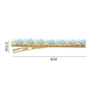 Detail view of 8cm gold hair clip with white pearls and blue crystal bead accents