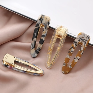 Set of marble effect acetate hair clips with golden metal clamps in various patterns