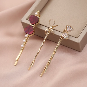 Dreiteiliges goldenes Haarspangen-Set mit rotem Herz Perle und Strass-Schleife