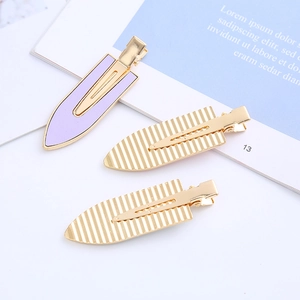 Three elegant gold and purple metal hair clips with minimalist textures for women