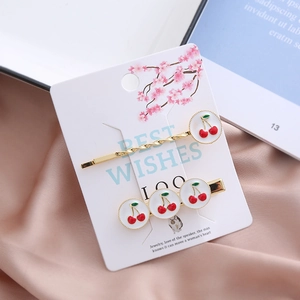 Lot de barrettes à cheveux cerises dorées avec émail rouge sur fond rose doux