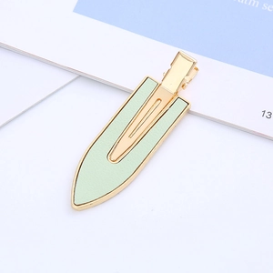 Detailed macro view of mint green leather inlay on a golden metallic hair clip