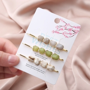 Three-piece hair clip set with faux natural stones on gold base displayed on cards
