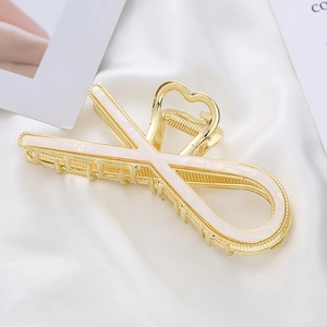 Elegant gold alloy shark hair claw clip with mother of pearl inlay on white silk background