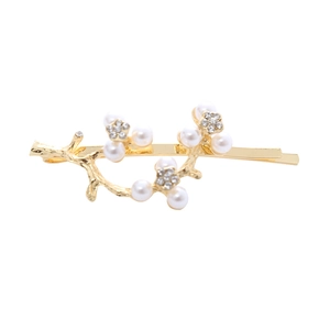 Elegant gold twig hair clip with white pearls and sparkling rhinestones on white background
