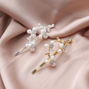 Elegant branch hair clips set with pearls and rhinestones on rose gold silk background