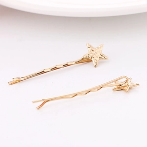 Detailed close-up of two golden star hair clips with matte texture and non-slip design