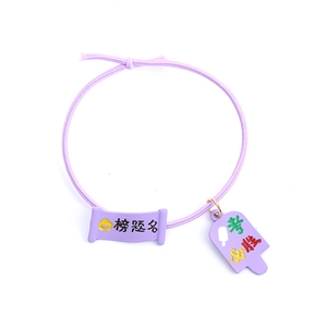 Close-up of purple elastic hair tie with lucky exam charms and scroll pendants