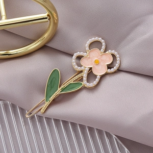 Eleganter Blumen-Haarclip mit Emaille-Blüten und Perlen auf lila Seidenstoff