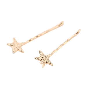 Golden minimalist star hair clips with textured hammered finish on a white background