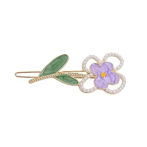 Detail der lila Blumen-Haarklammer mit grünen Blättern, Perlen und Gold-Metallbasis
