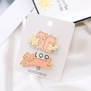 Pink and gold Japanese cartoon cat hair clips with star charms on white satin