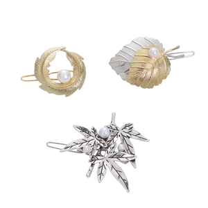 Elegant gold and silver leaf hair clips set with pearls on a clean white background