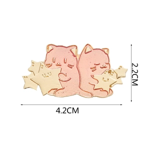 Detail view of pink enamel cat brooches with gold edges showing 4.2cm width dimensions