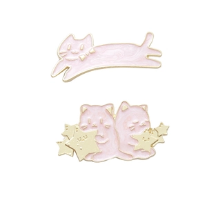 Close-up of pink enamel cat pins with gold metal borders and star designs