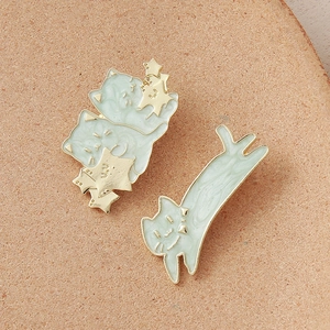 Detail of mint green cat hair clips with gold enamel finish and starry patterns