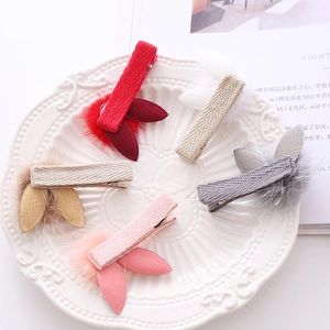 Set of five plush rabbit ear hair clips with fuzzy pom-poms on woven fabric base