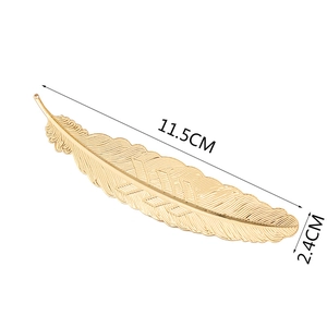 Detailed macro view of golden maple leaf hair clip with fine metal texture and veins