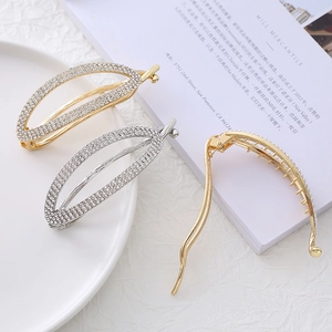 Dettaglio di eleganti fermagli per capelli ovali con perle e strass dorati