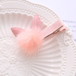 Cute pink plush bunny ear hair clip for women with soft faux fur on a white plate