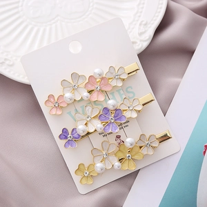 Three-piece Korean floral hair clip set with pearls and rhinestones on card display