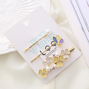 Floral hair clip set with butterfly and pearl accents on elegant display card