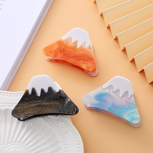 Detailed close-up of Mount Fuji style hair claws in amber, black, and blue-purple acetate