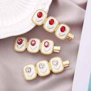 Detailed view of three tulip crystal hair clips with red pink and white stones